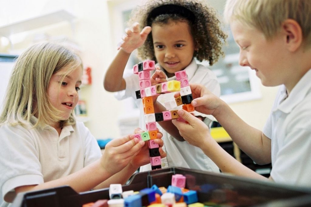 school children building with blocks